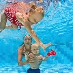 Baby underwater swimming lesson with instructor in the pool