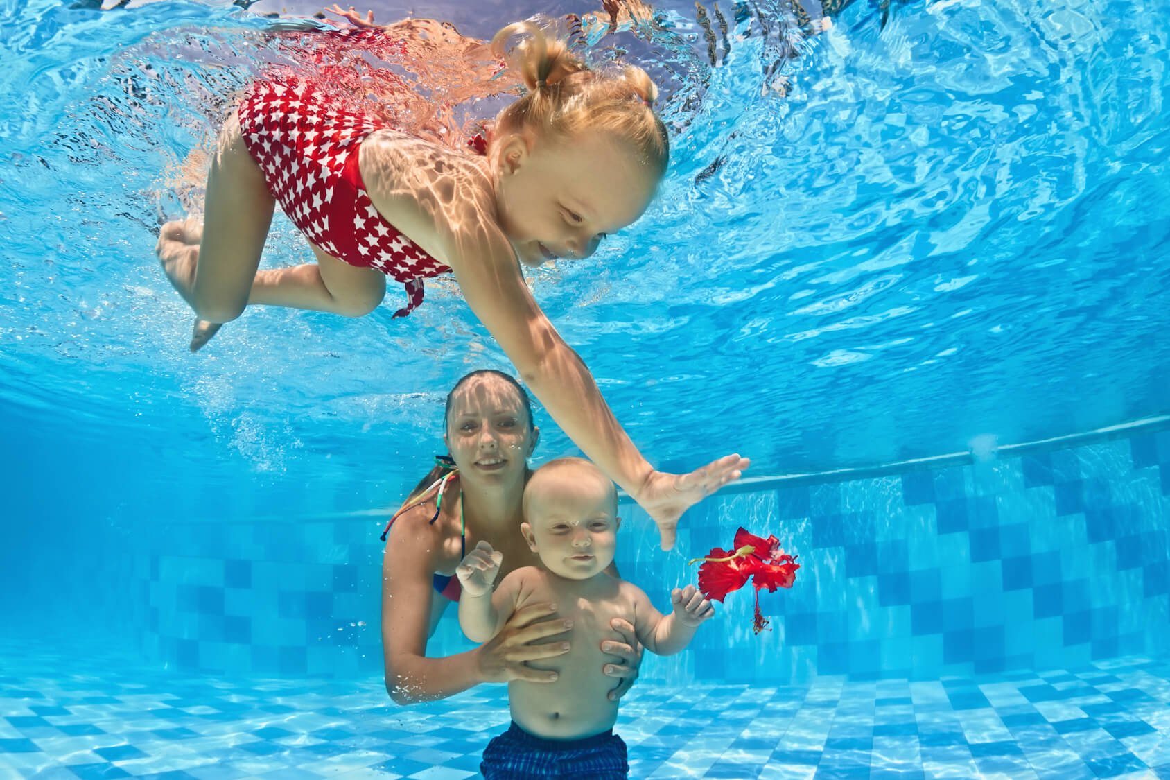 Baby underwater swimming lesson with instructor in the pool